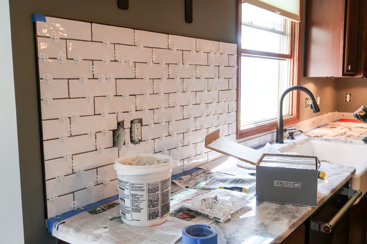 installing a white subway tile backsplash