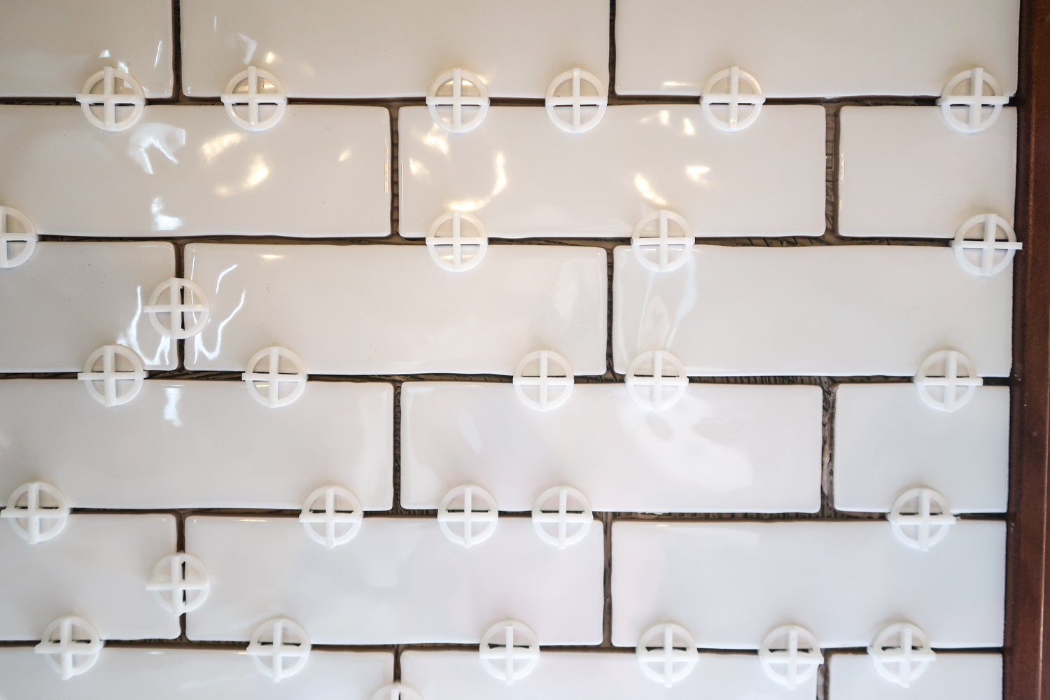 spacers between white subway tile backsplash