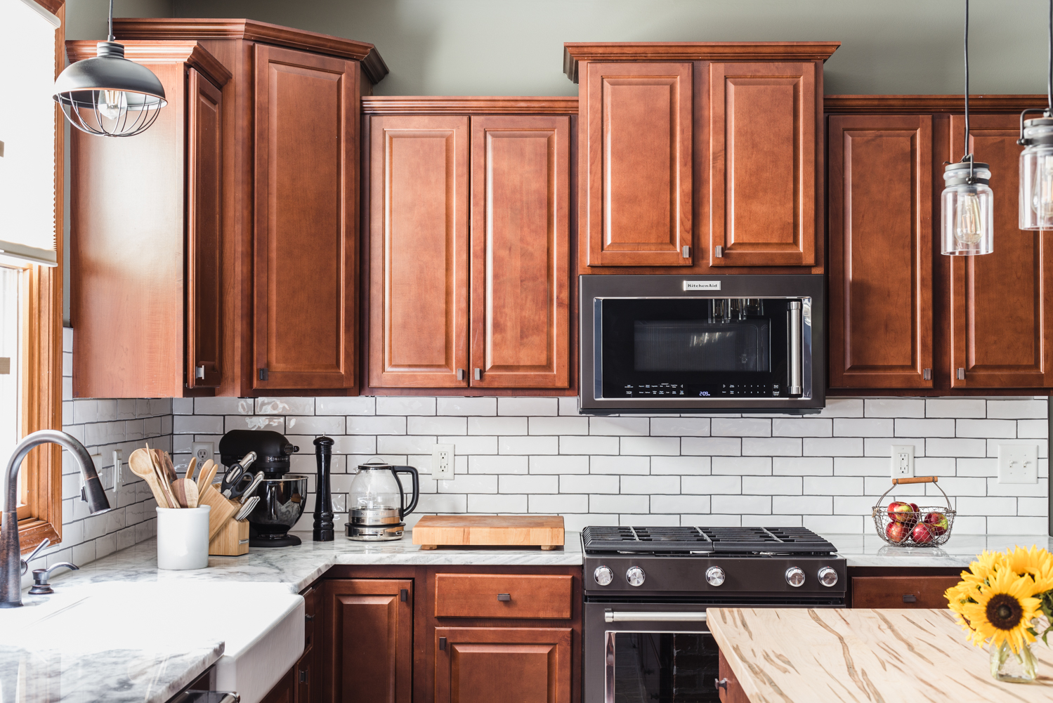 black stainless appliances in kitchen with white subway tile