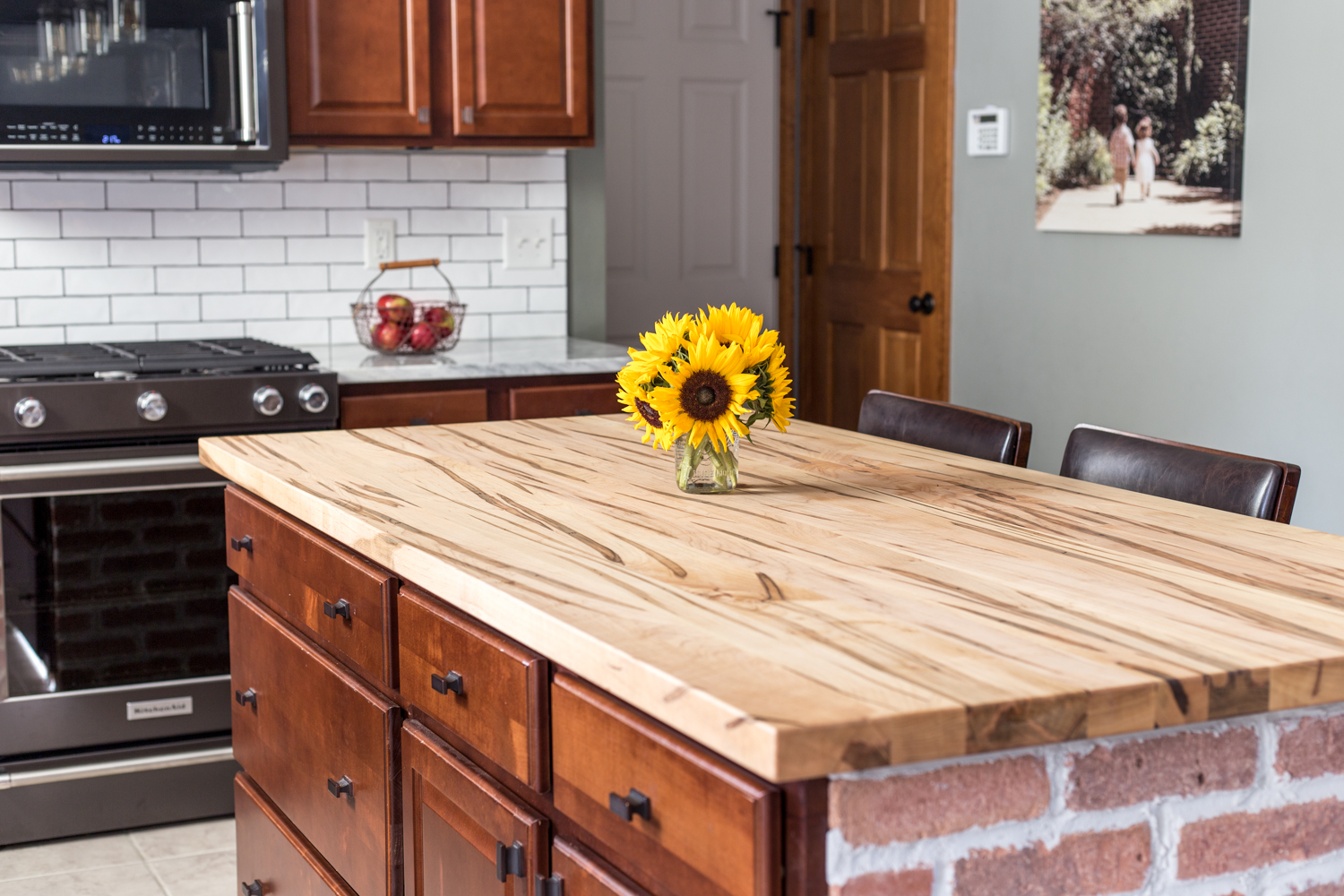 wooden countertop on brick island kitchen