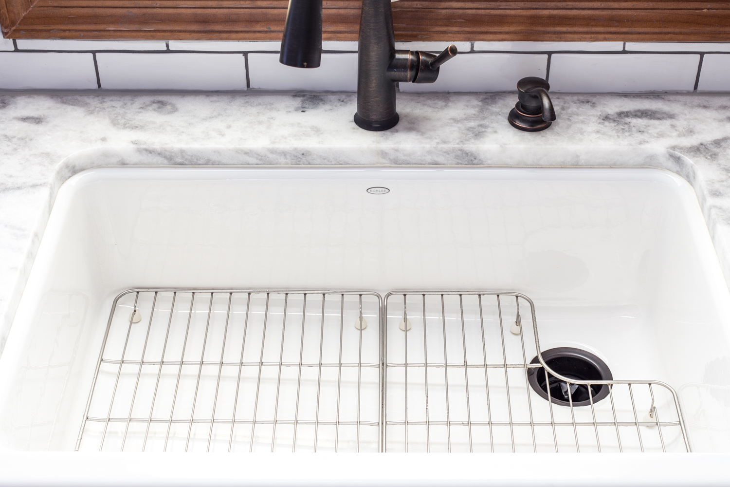 white farm sink with quartzite counter and white subway tile backsplash