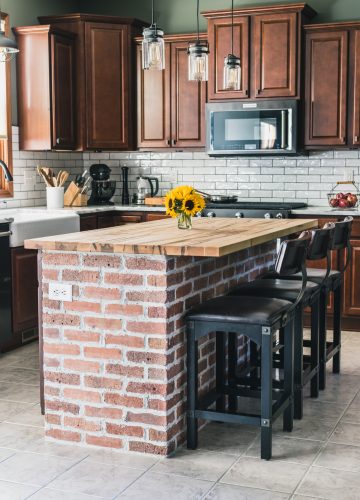 Exposed brick kitchen island with wooden countertop