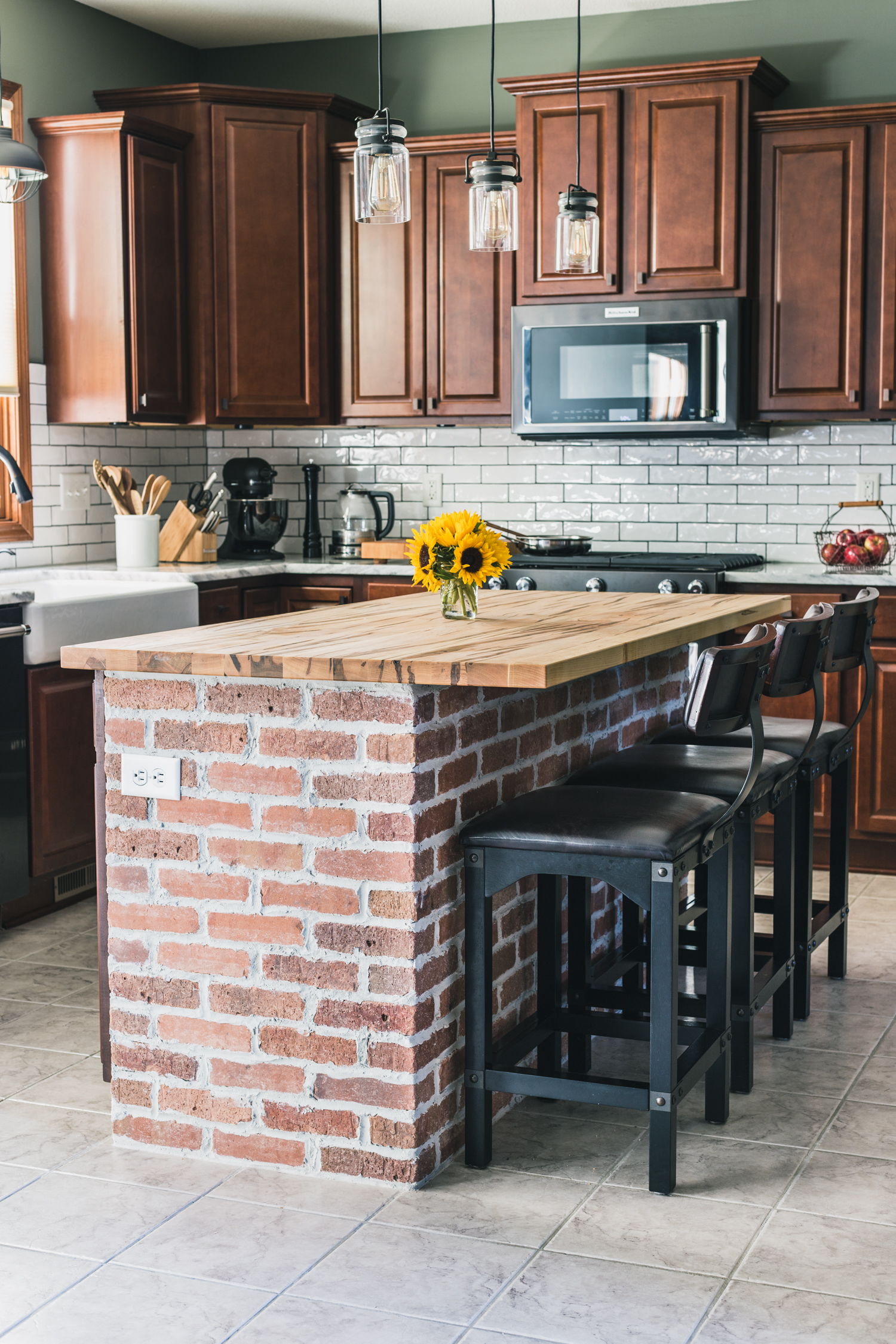 Exposed brick kitchen island with wooden countertop