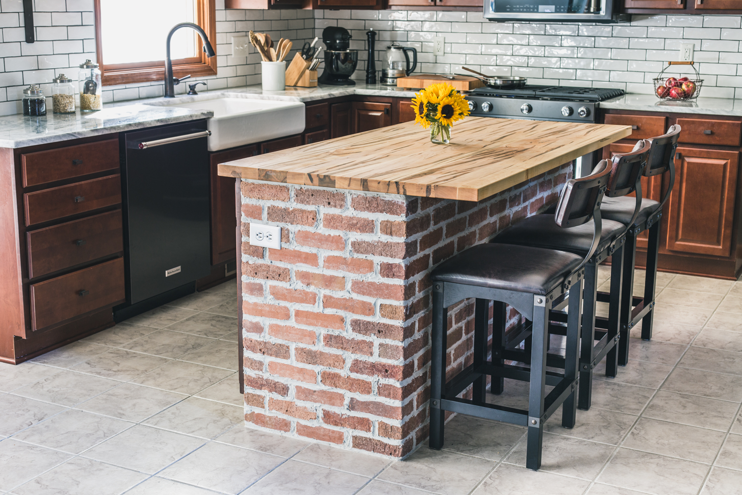 Kitchen island with exposed brick and wooden countertop