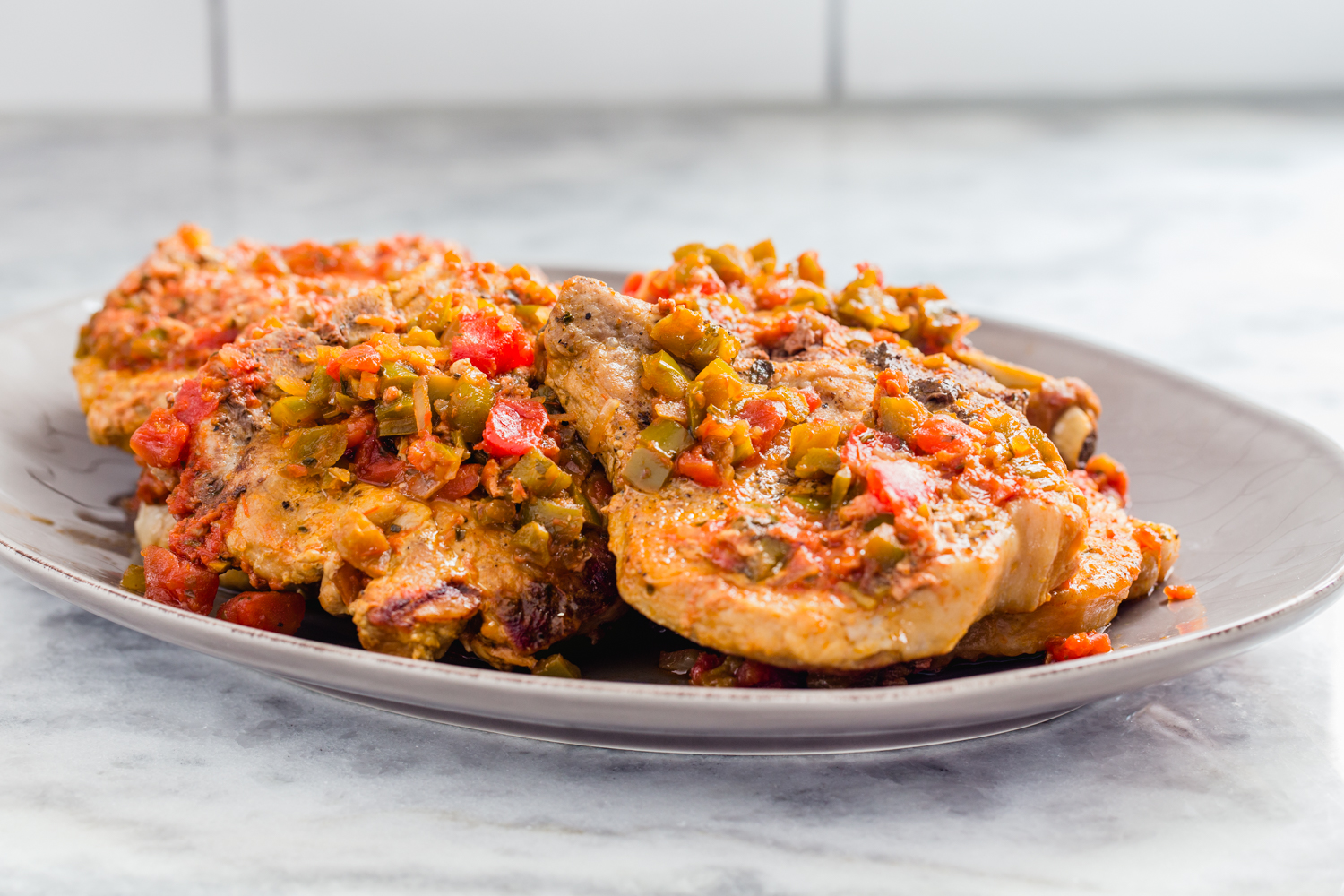 platter of pork chops with salsa on marble counter