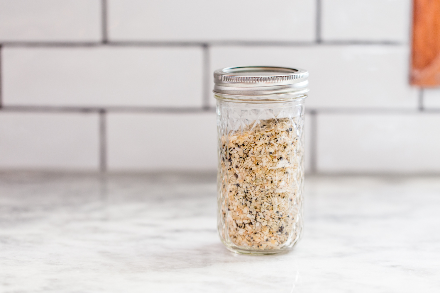 everything bagel seasoning in jar on marble countertop